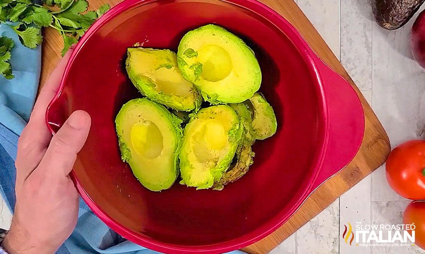 avocados in a red mixing bowl