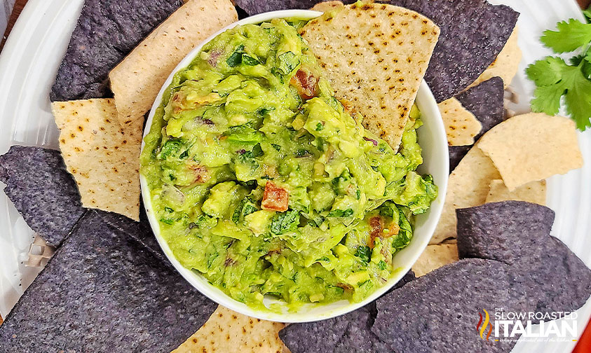 top view of chunky guacamole in a bowl with chips