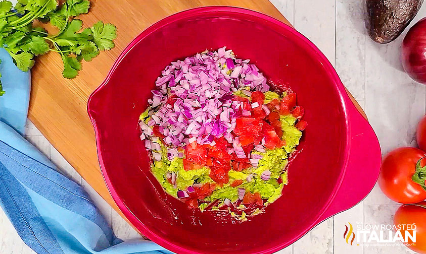 avocado, onion, and tomatoes in a mixing bowl