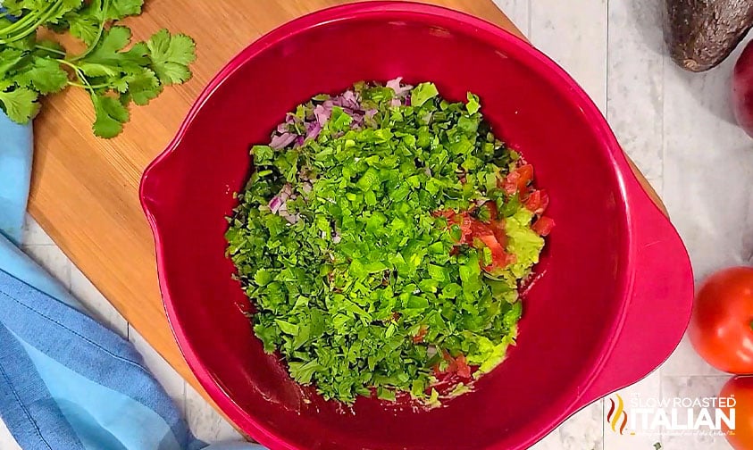 adding jalapeno and cilantro to mixing bowl