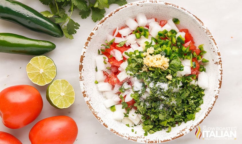 onion, cilantro, jalapeños, tomatoes and garlic in a bowl