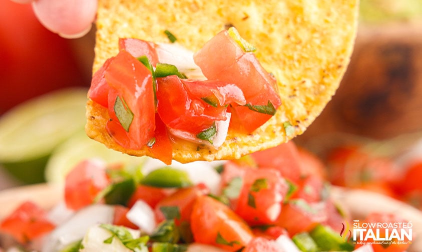 closeup of pico de gallo on a tortilla chip