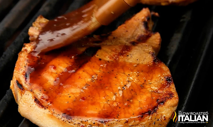 brushing pork chop with jack daniel's sauce