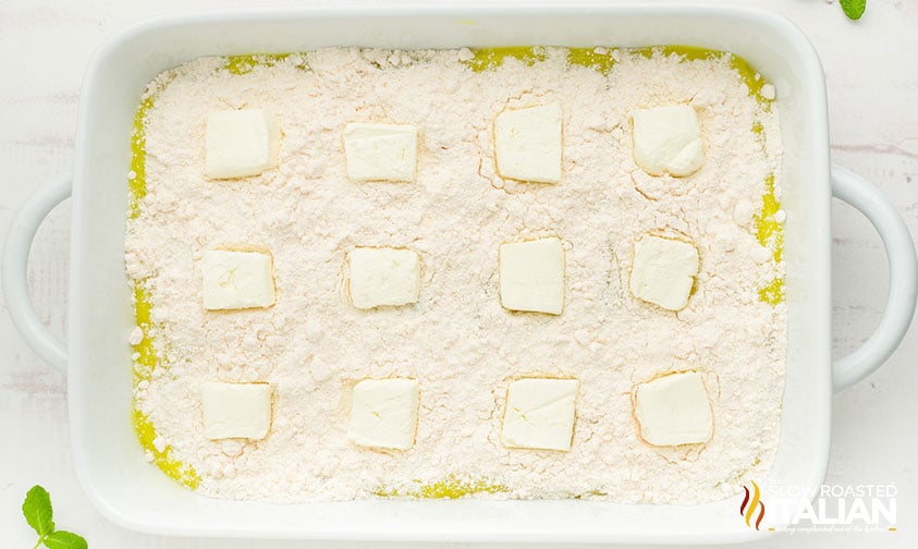 sliced cream cheese over dry cake mix