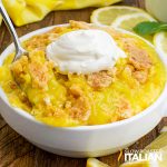 bowl of lemon dump cake with a dollop of whipped cream