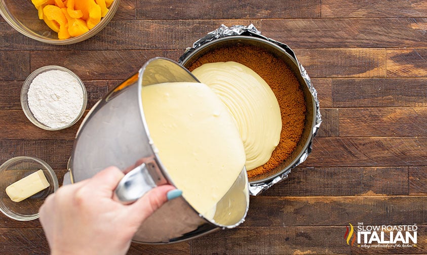 pouring cheesecake filling onto prepared crust in springform pan