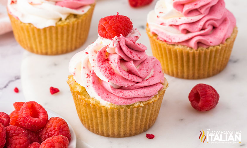 swirled icing and fresh raspberry on raspberry cupcakes