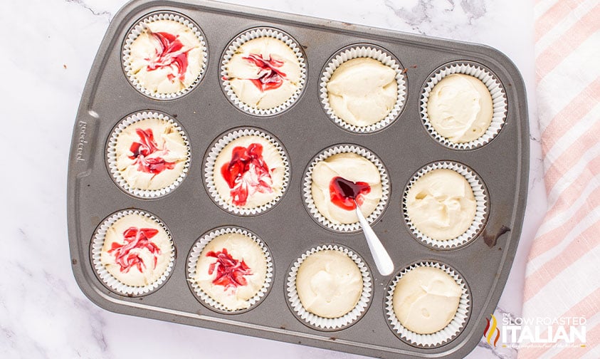 adding raspberry sauce to batter in muffin pan