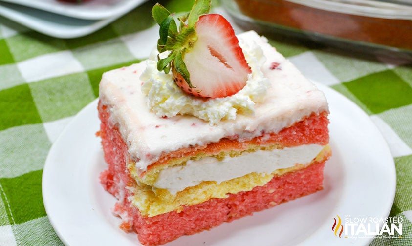 delicious piece of strawberry twinkie cake with dollop of whipped cream and fresh strawberry on top