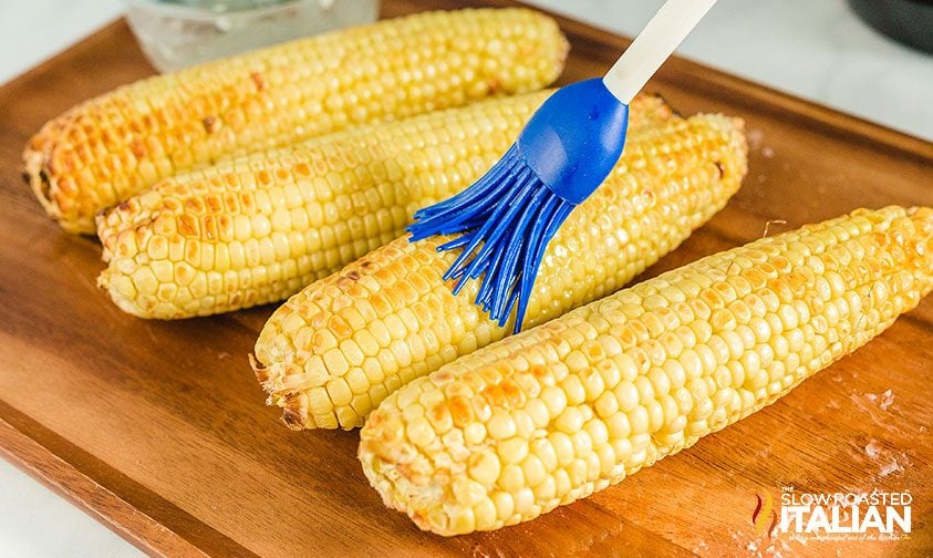 brushing butter onto air fried corn on the cob