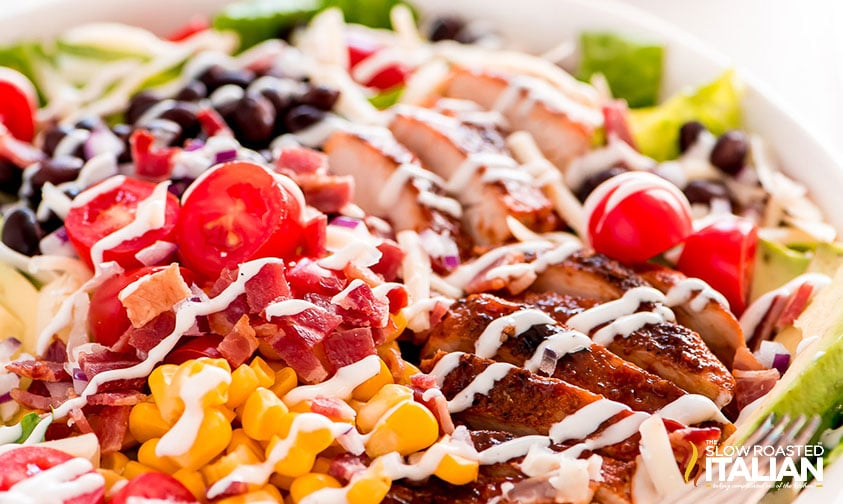 close up: bbq chicken salad with black beans and corn drizzled with ranch dressing
