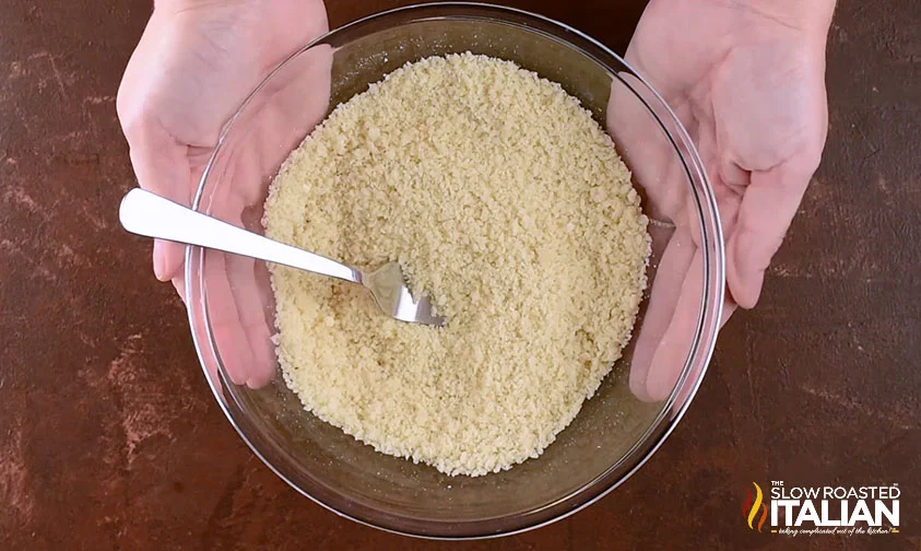 holding bowl of panko parmesan breading for zucchini