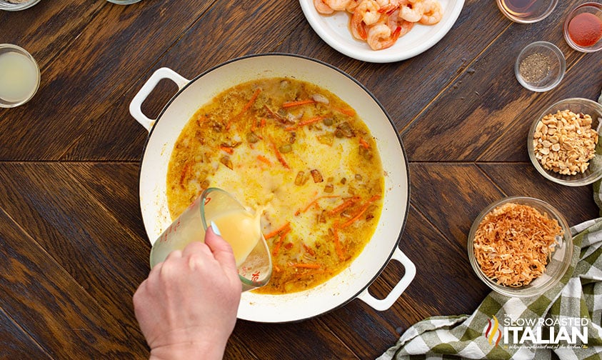 pouring chicken broth into skillet for bang bang shrimp sauce