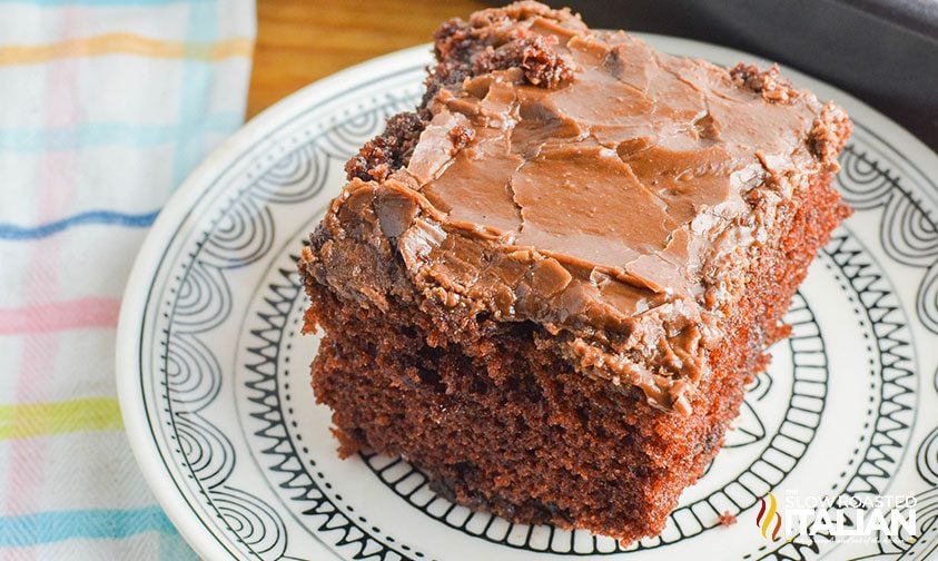 slice of frosted fudge cake on patterned plate