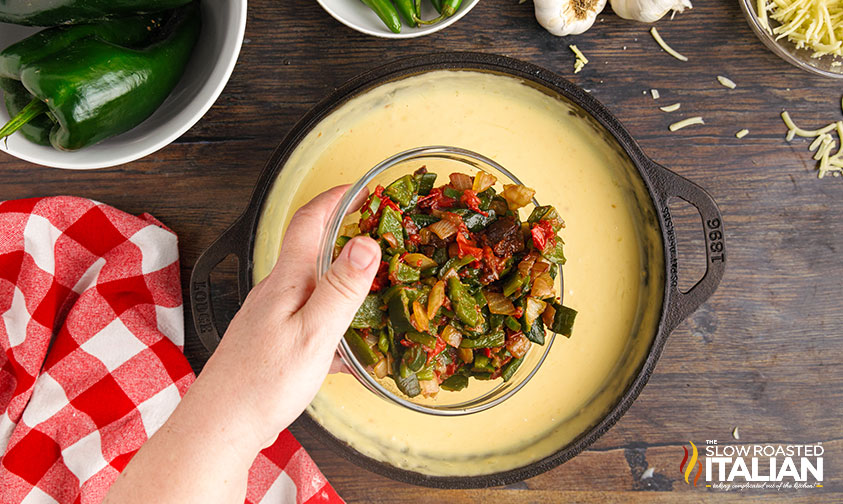 adding veggies to queso dip