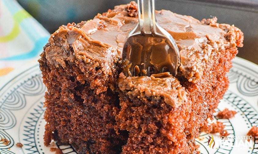 fork inserted into slice of chocolate cake