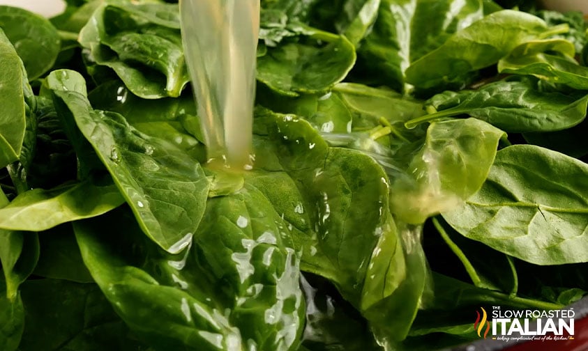 pouring liquid over spinach leaves