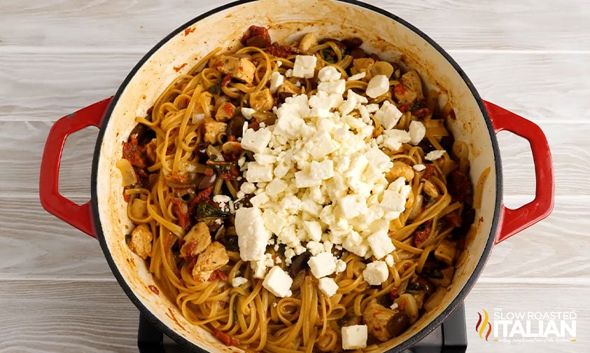 crumbled feta over greek chicken pasta in pot