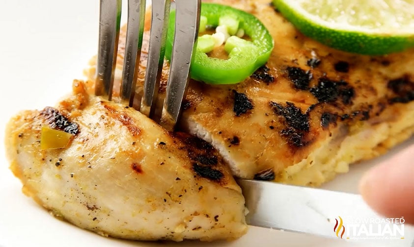 slicing off a piece of grilled margarita chicken