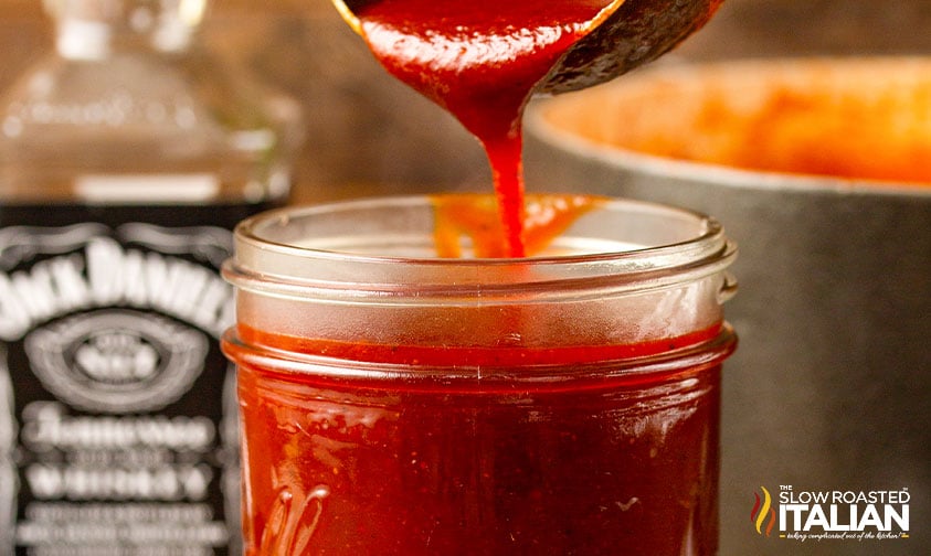 pouring whiskey bbq sauce into jar