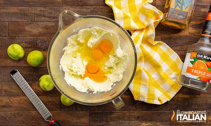 cracked eggs over cupcake batter in bowl