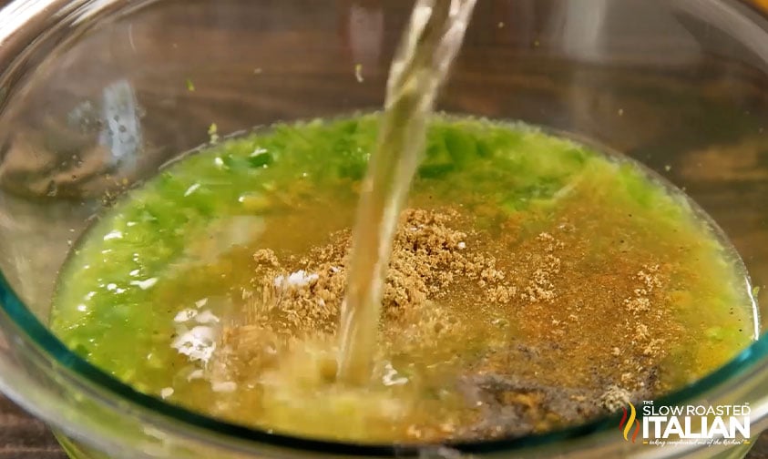 pouring tequila into bowl with other marinade ingredients