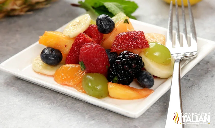 orange fruit salad on square plate with fork