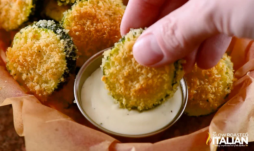 dipping breaded zucchini chip in creamy sauce