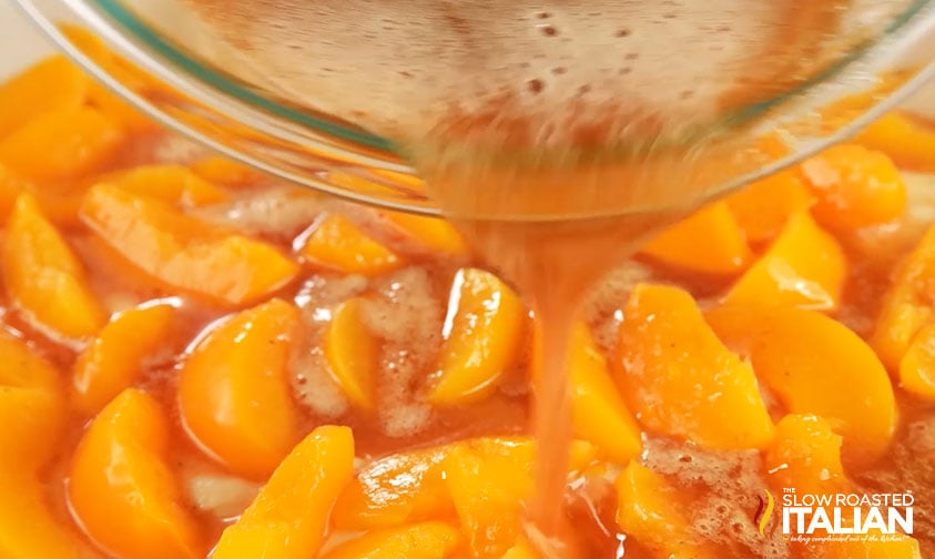 pouring spiced peach juice over canned peaches