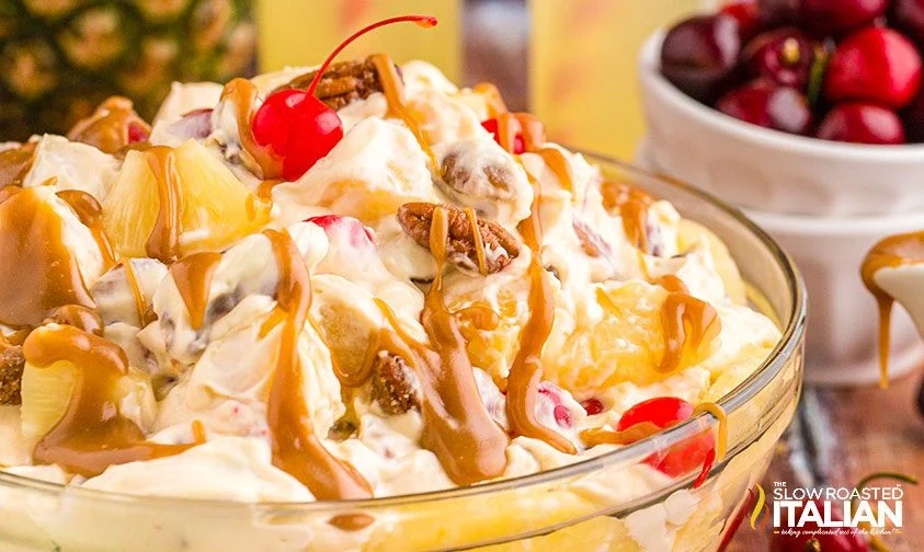 close up: bowl of creamy pineapple dessert salad with cherries and caramel