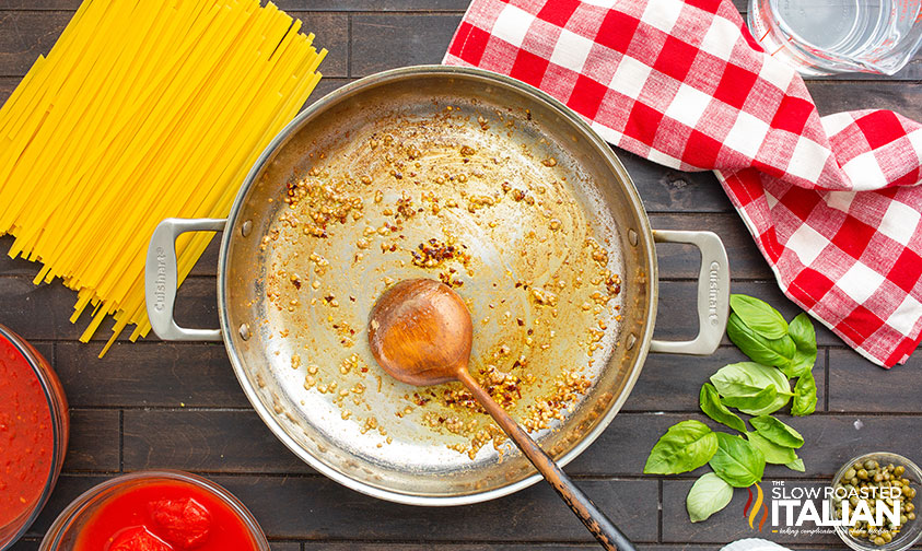 stirring garlic, anchovy paste, and red pepper flakes in skillet