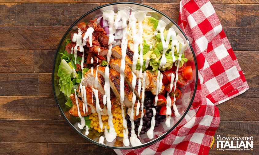 ranch dressing drizzled over a bowl of bbq chicken salad