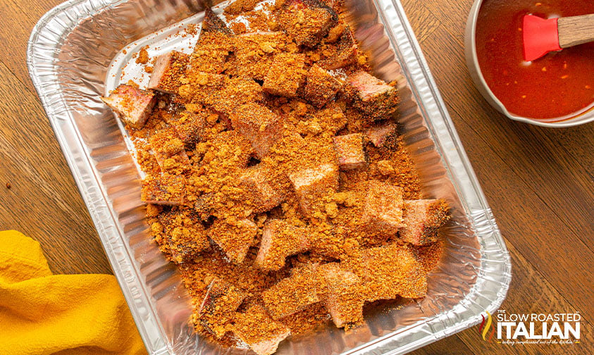 chopped brisket covered in brown sugar and spices in foil pan