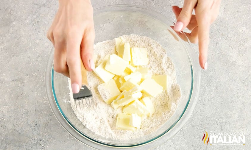 cutting cold butter into flour mixture with pastry cutter