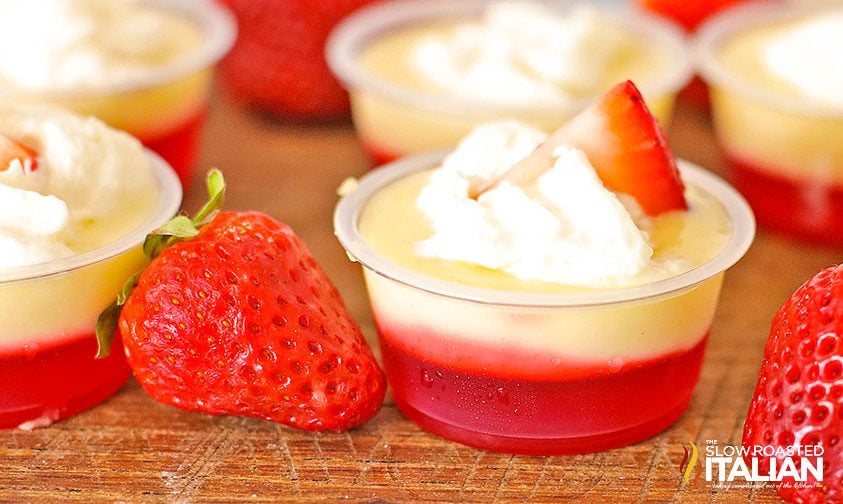 strawberry cheesecake shot topped with whipped cream and strawberry slice
