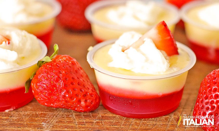 strawberry cheesecake shot topped with whipped cream and strawberry slice