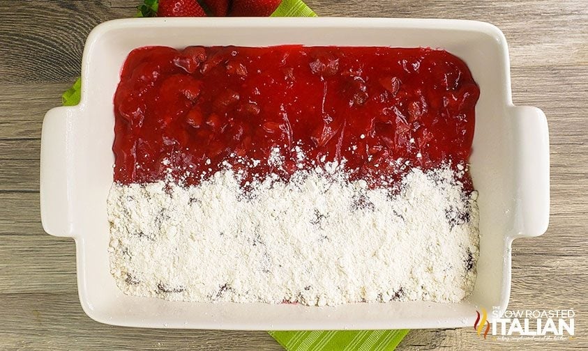 cake mix sprinkled over half the pie filling in a baking dish