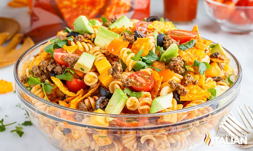 taco salad with doritos and pasta in large clear bowl