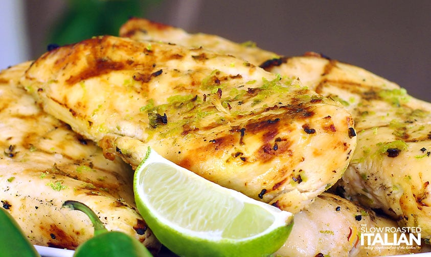 pile of grilled chicken breasts with lime wedge