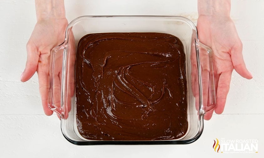 brownie batter spread into glass baking dish