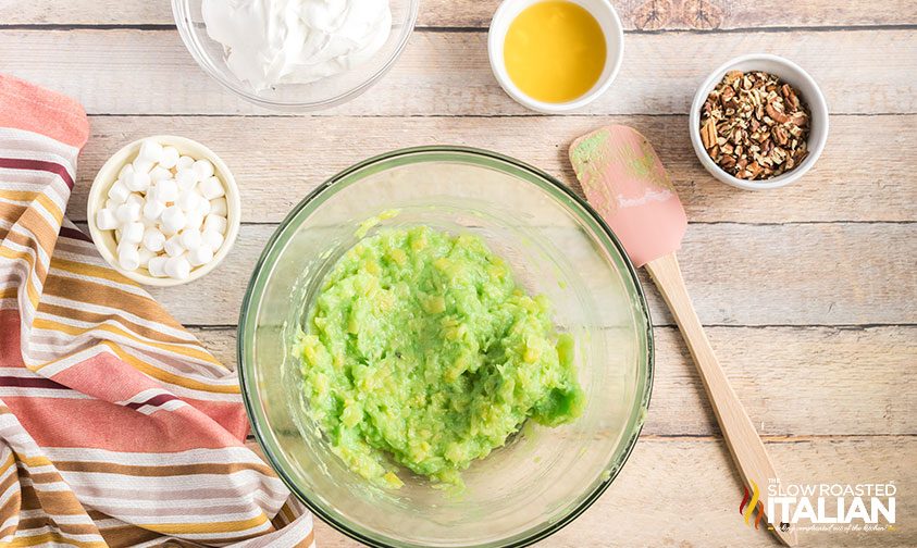 crush pineapple combined with pistachio pudding mix in bowl