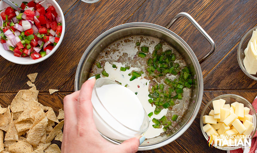 pouring cream into pot with sauteed onion and jalapeno