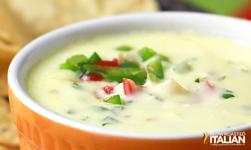 close up of white cheese dip in orange ramekin