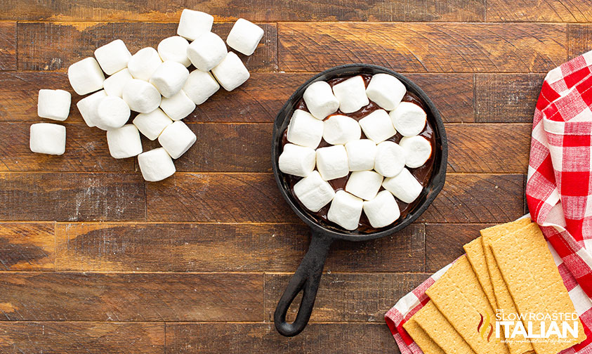 adding marshmallows to melted chocolate