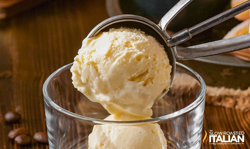 scooping vanilla gelato into glass cup