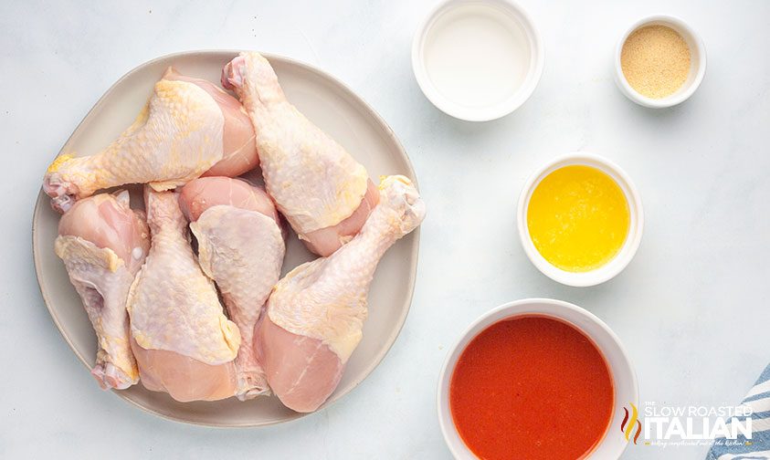 raw chicken drumsticks with ingredients for buffalo sauce