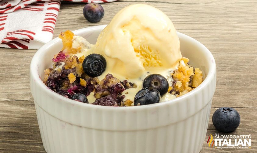 serving of blueberry dump cake in ramekin with ice cream