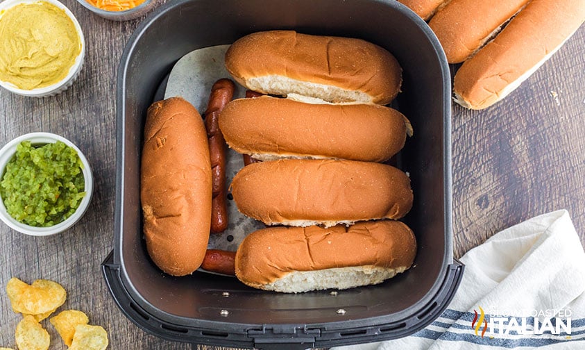 buns on top of hot dogs in air fryer basket