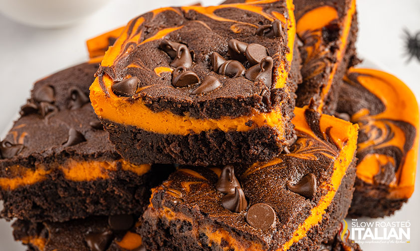 stack of brownies with orange cheesecake layer