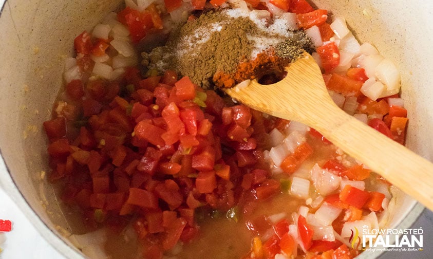 stirring spices into veggies in pot